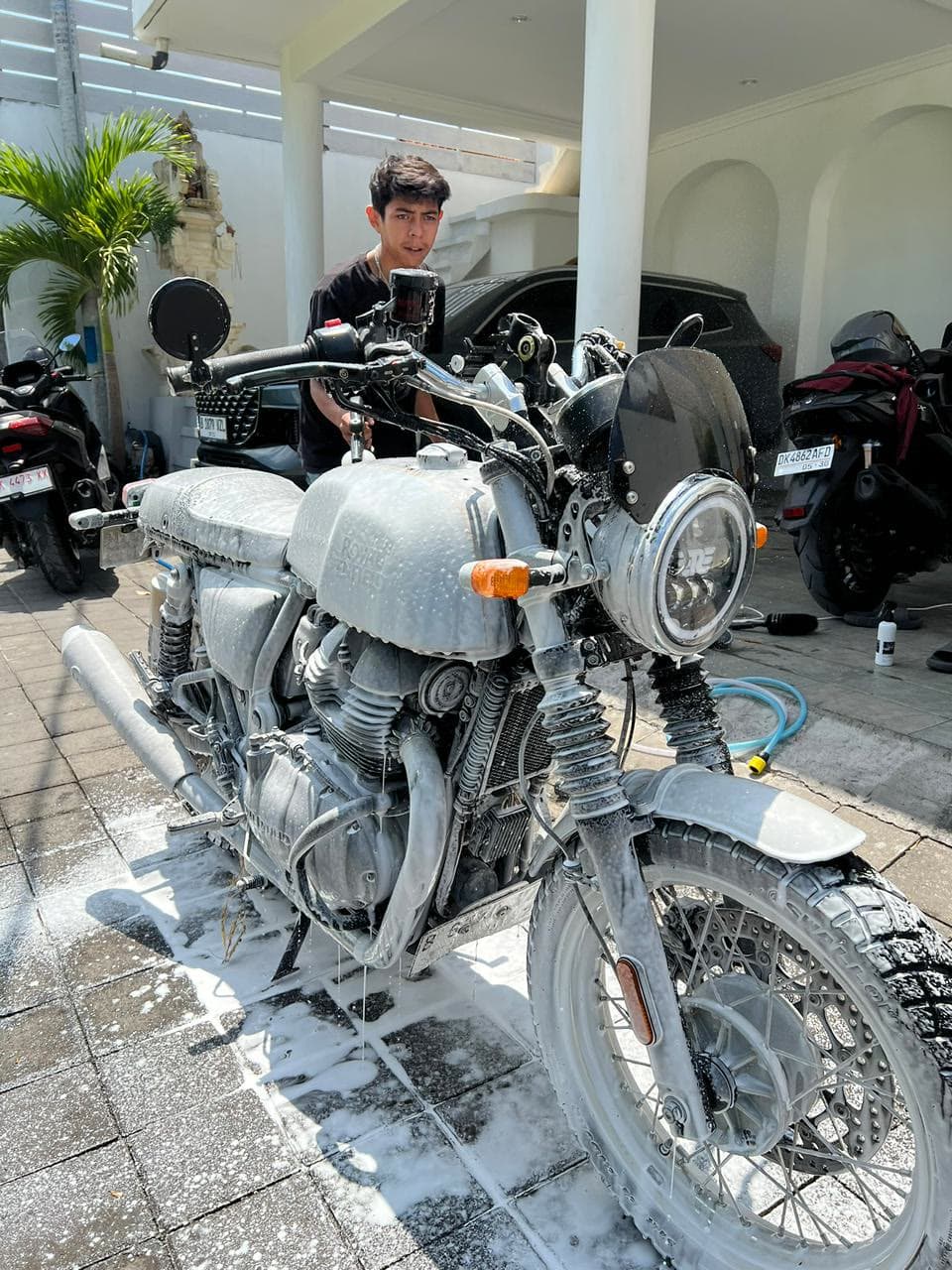 SparkWash technician washing a motorbike at a villa in Bali